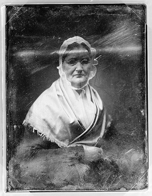 A daguerreotype portrait of an elderly woman in glasses