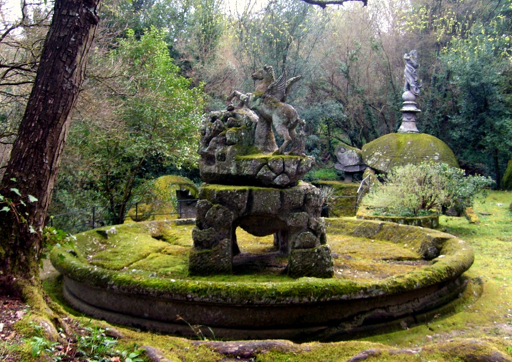 Stone statue of pegasus covered by moss.