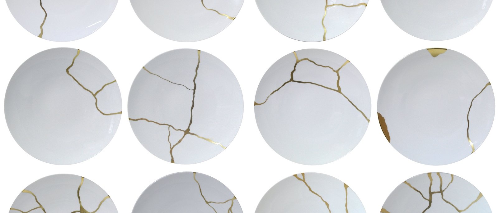 White bowls with the cracks mended with gold to allow the cracks to be shown, rather than hidden.