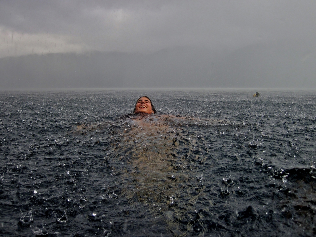 Woman in lake with rain falling
