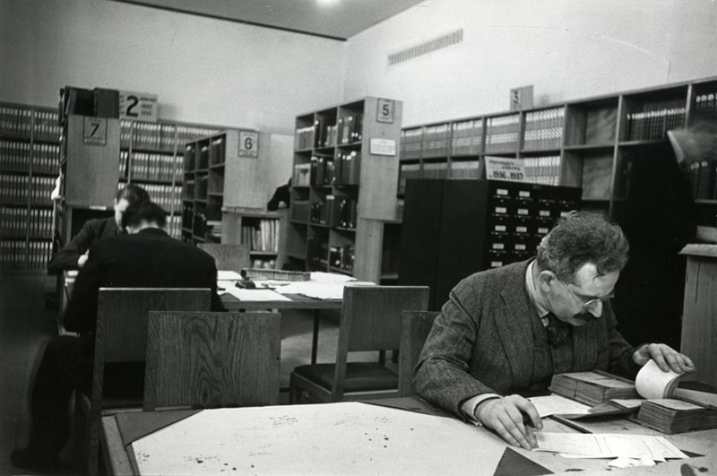 Walter Benjamin reading at a table in the library