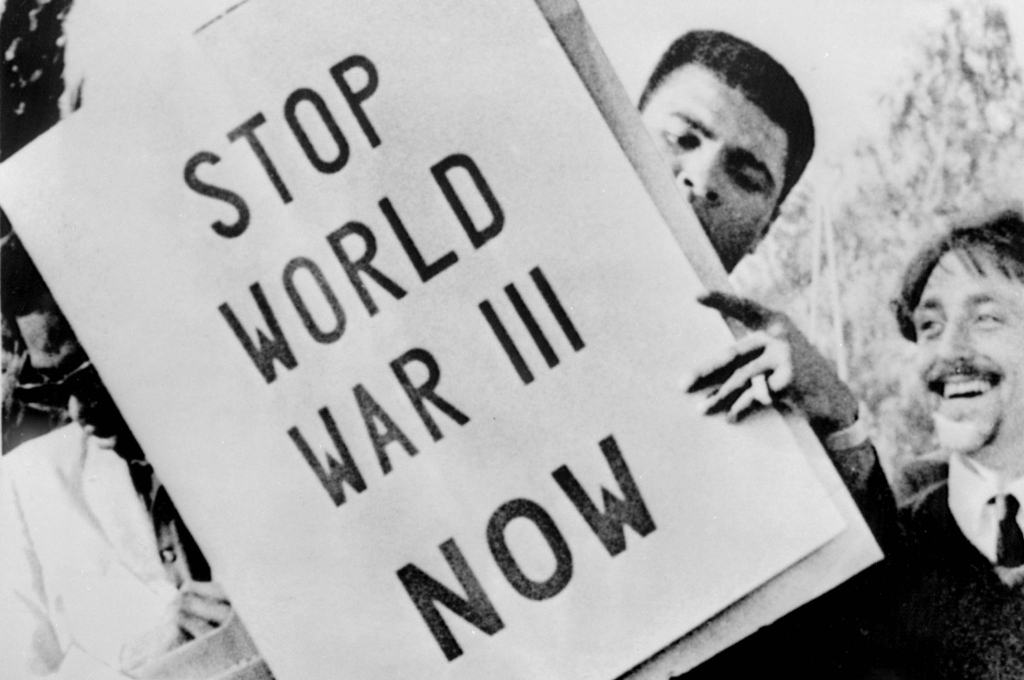 muhammad ali holding "stop world war III now" poster