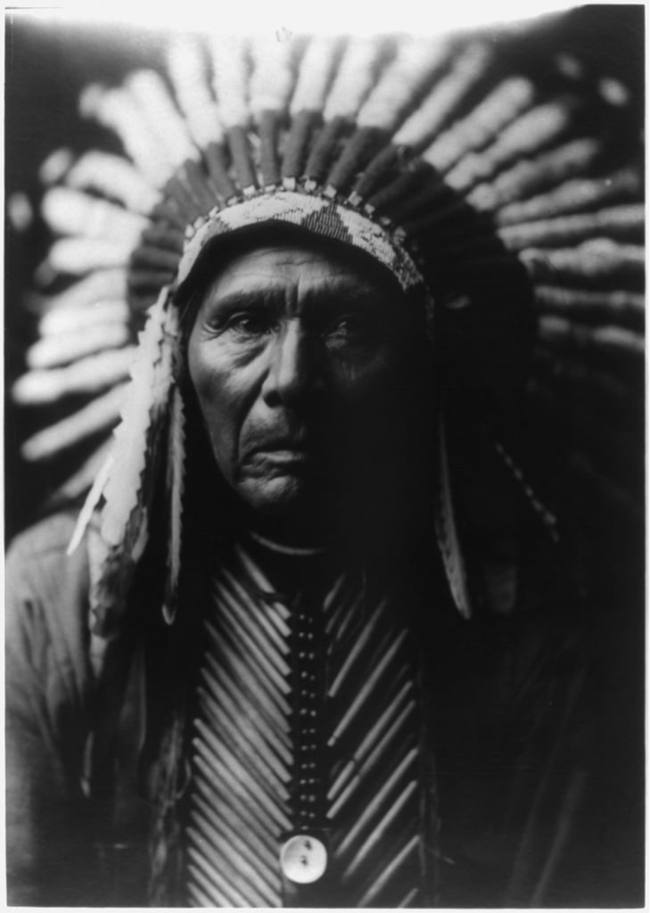 Native American chief with large head piece and matching vest