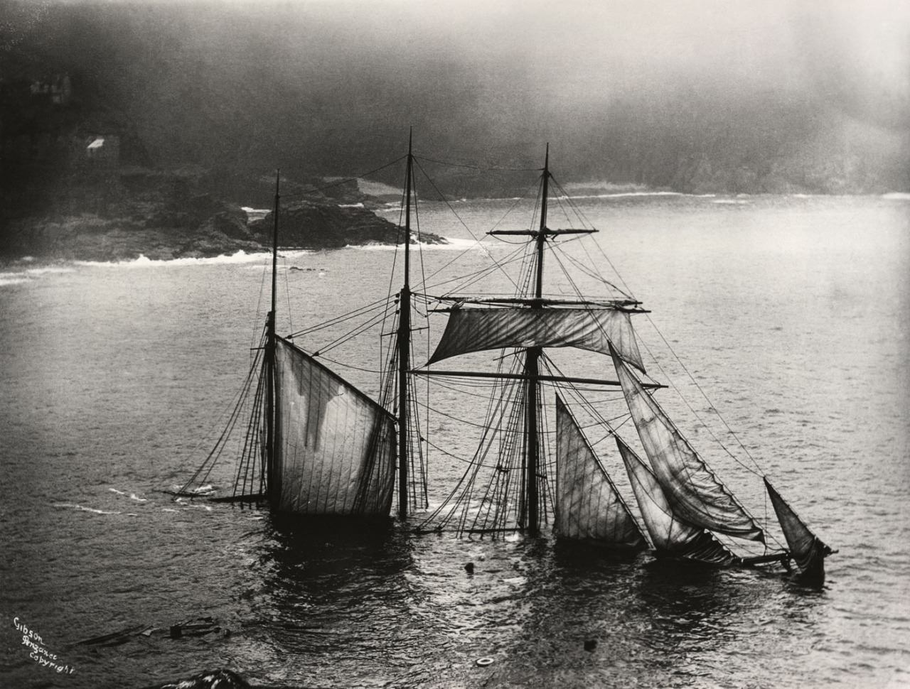 Masts of sunken ship above the water 