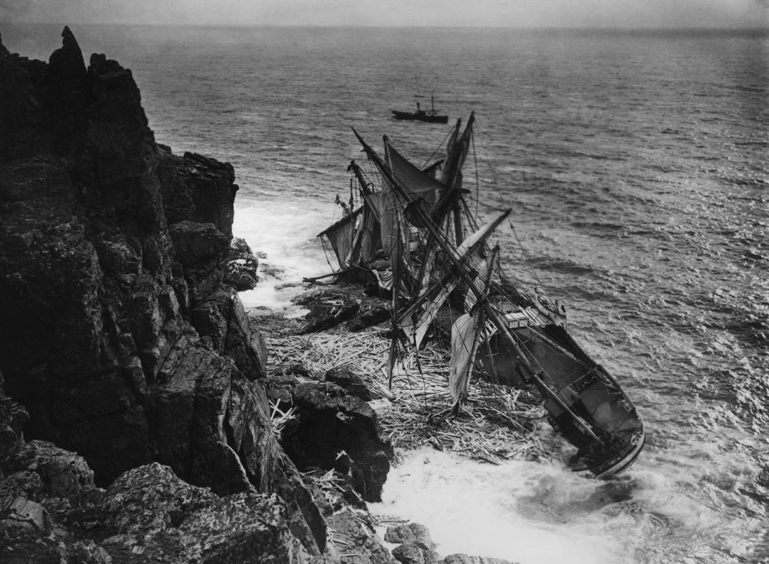 Wrecked ship on black rocks