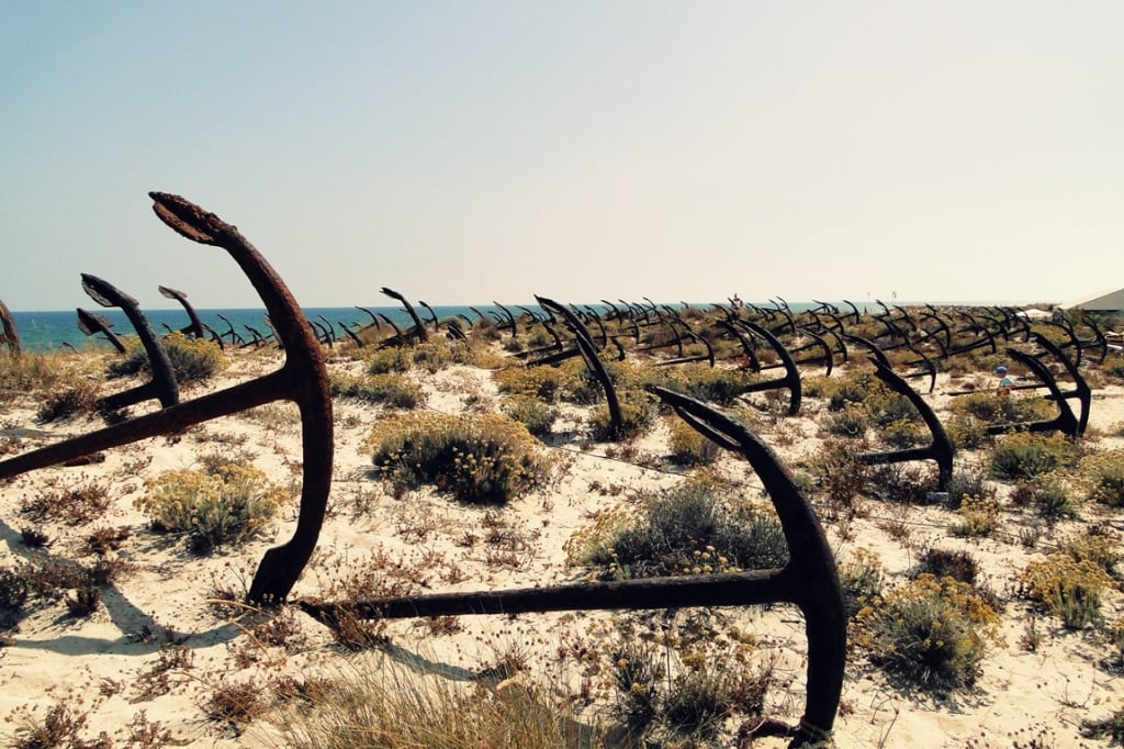 Lines of old anchors on beach.