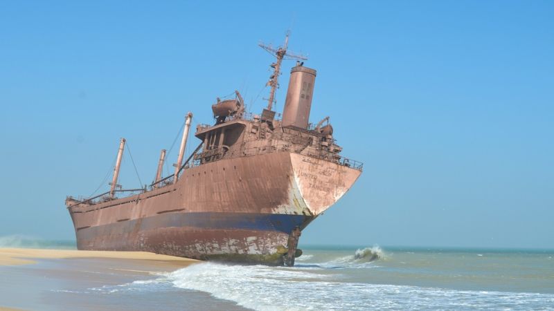 Rusted ship on beach.