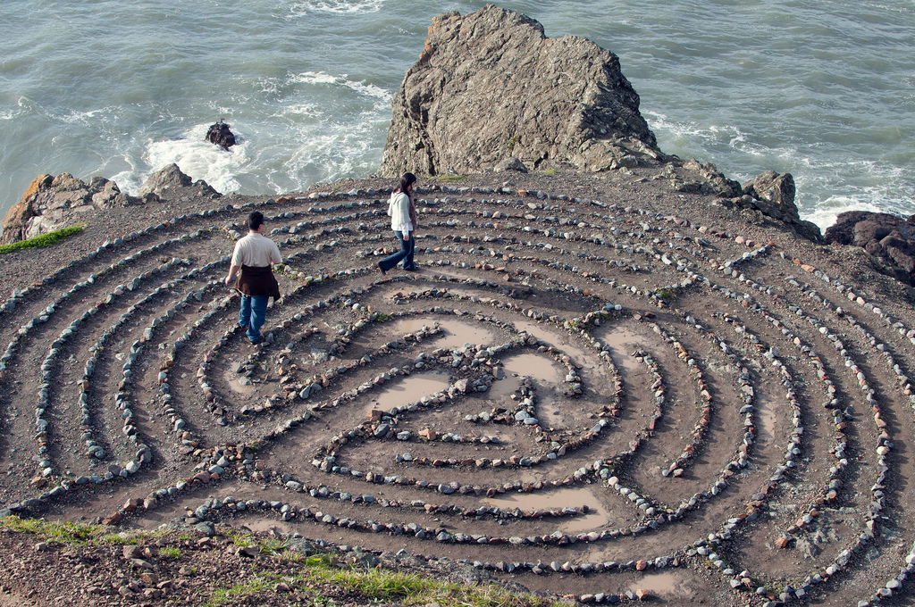 People walking through rock maze near ocean 
