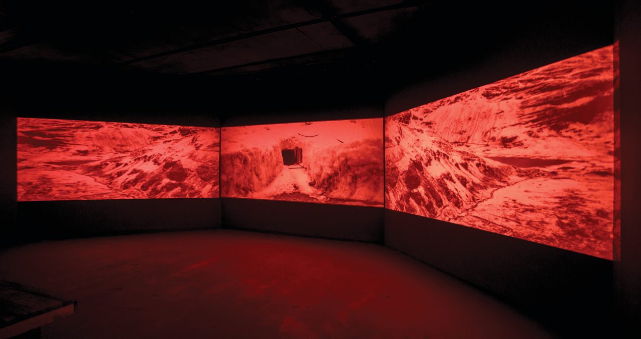 art installation with three large red video screens