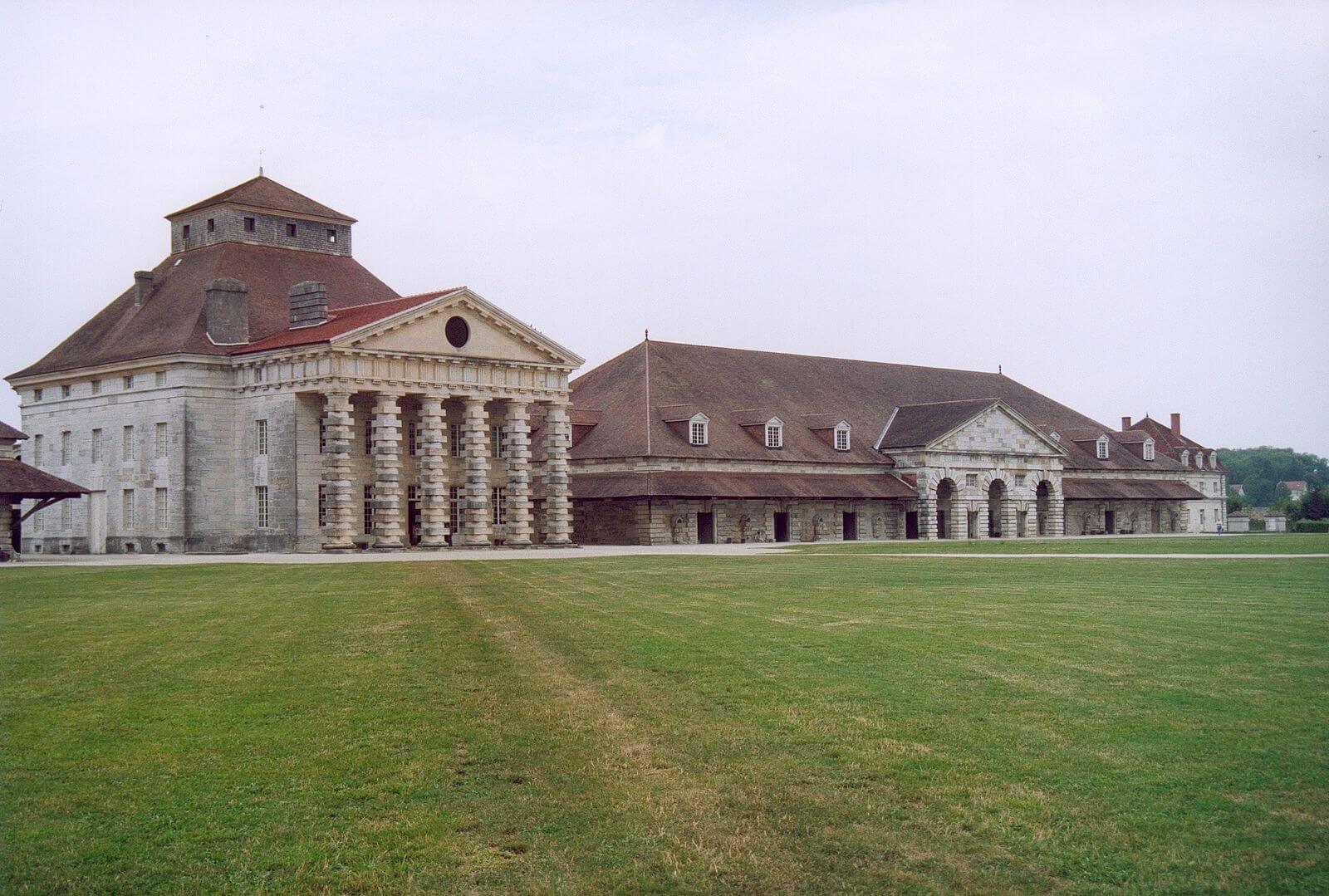Two large stone buildings with a large grass lawn out front