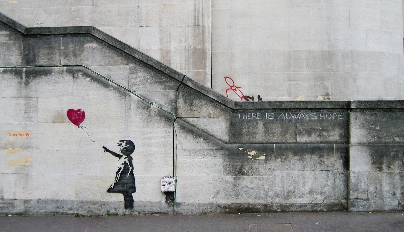 Banksy spray paint art of a girl holding a red balloon.