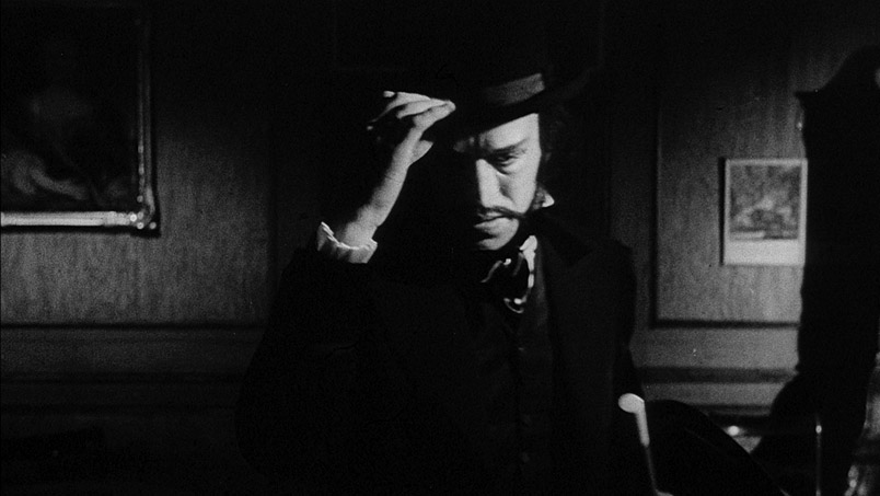 Black and white photo of man removing bowler hat.