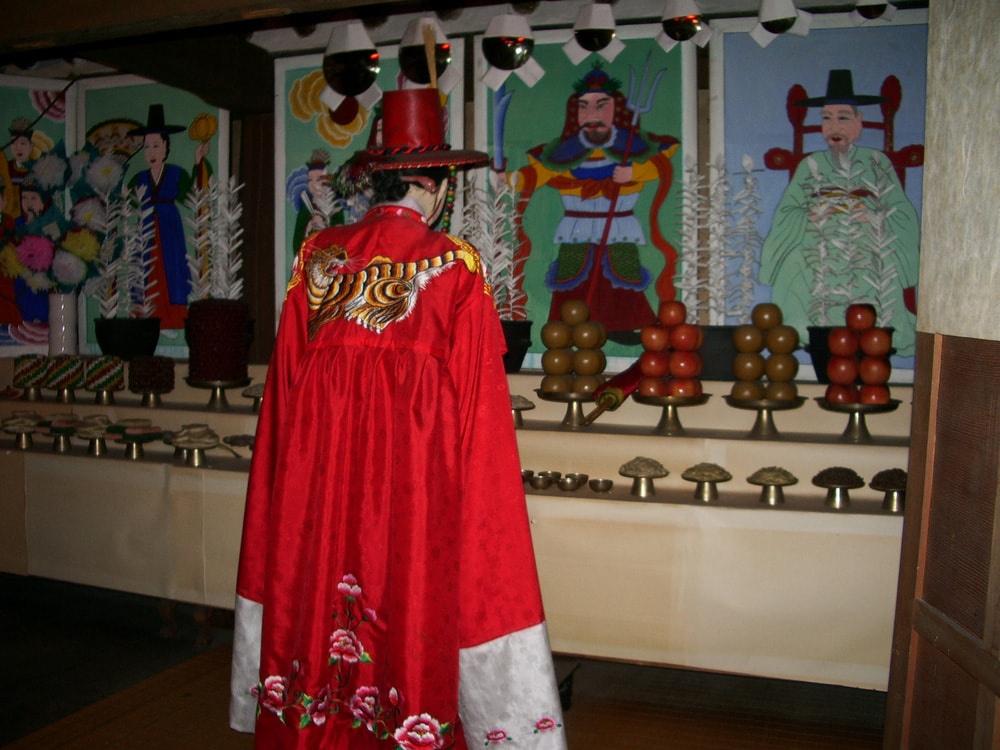 A female Shaman observing a table of offerings