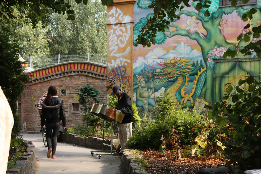 A woman walks down a path with a bridge ahead 