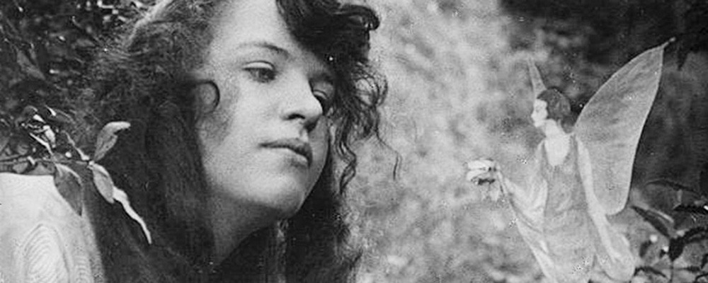 Black and white photo of a woman looking at fairies