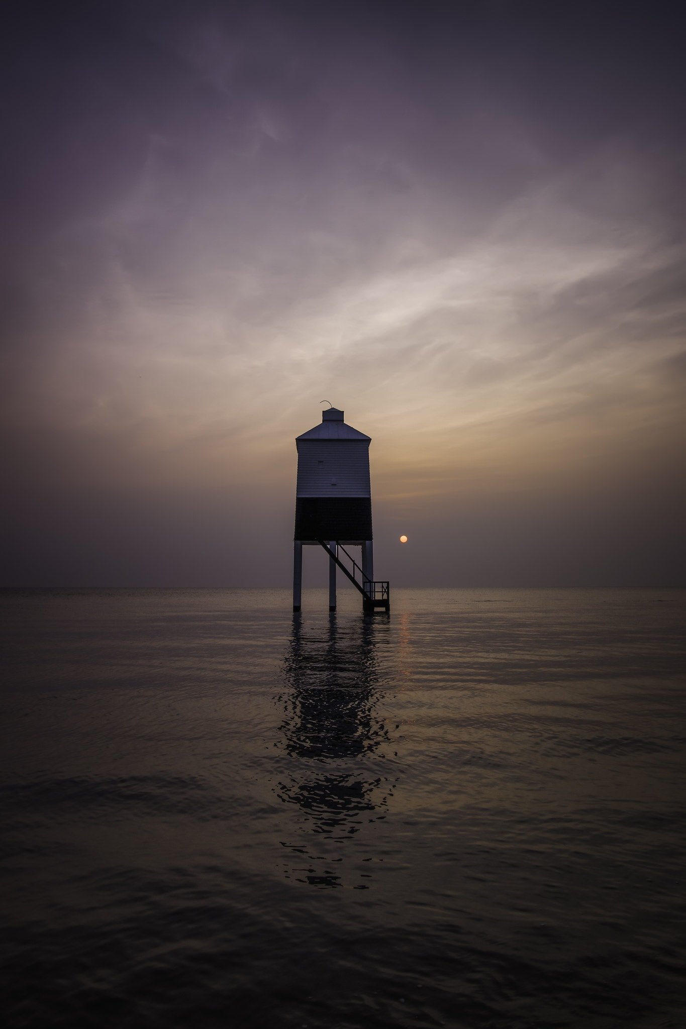 Lighthouse on stilts surrounded by water