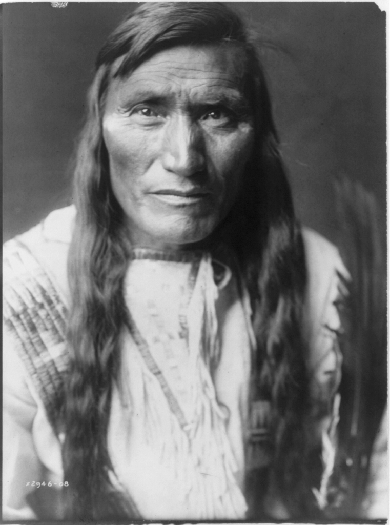 Long haired Native American with bangs in traditional clothing