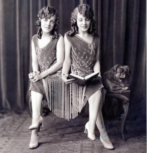 Siamese Twins sitting side by side reading a book