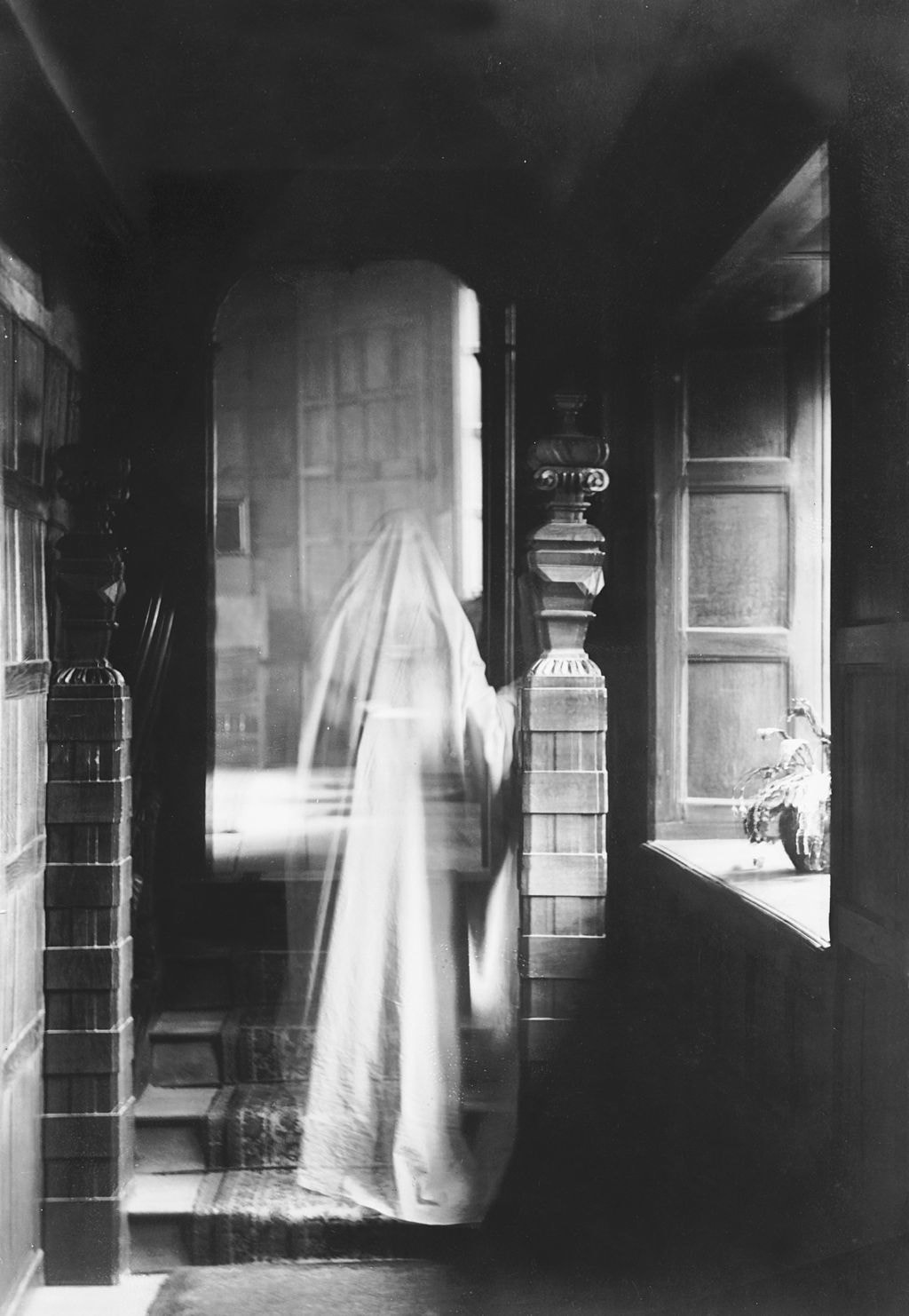 A fictional depiction of a ghost in a long white veil walking down a hallway.