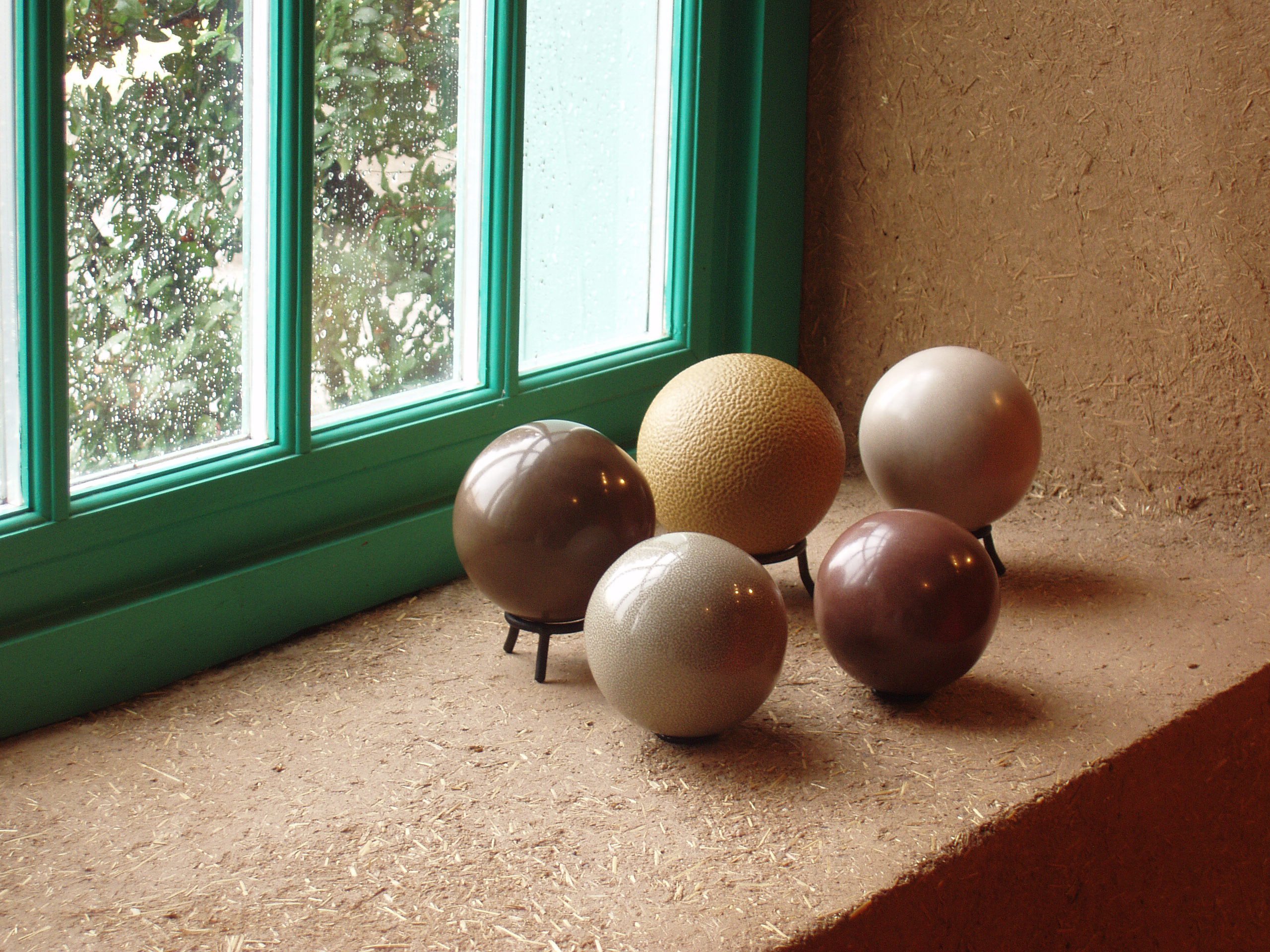 Porcelain spheres in different shades of brown on window sill.