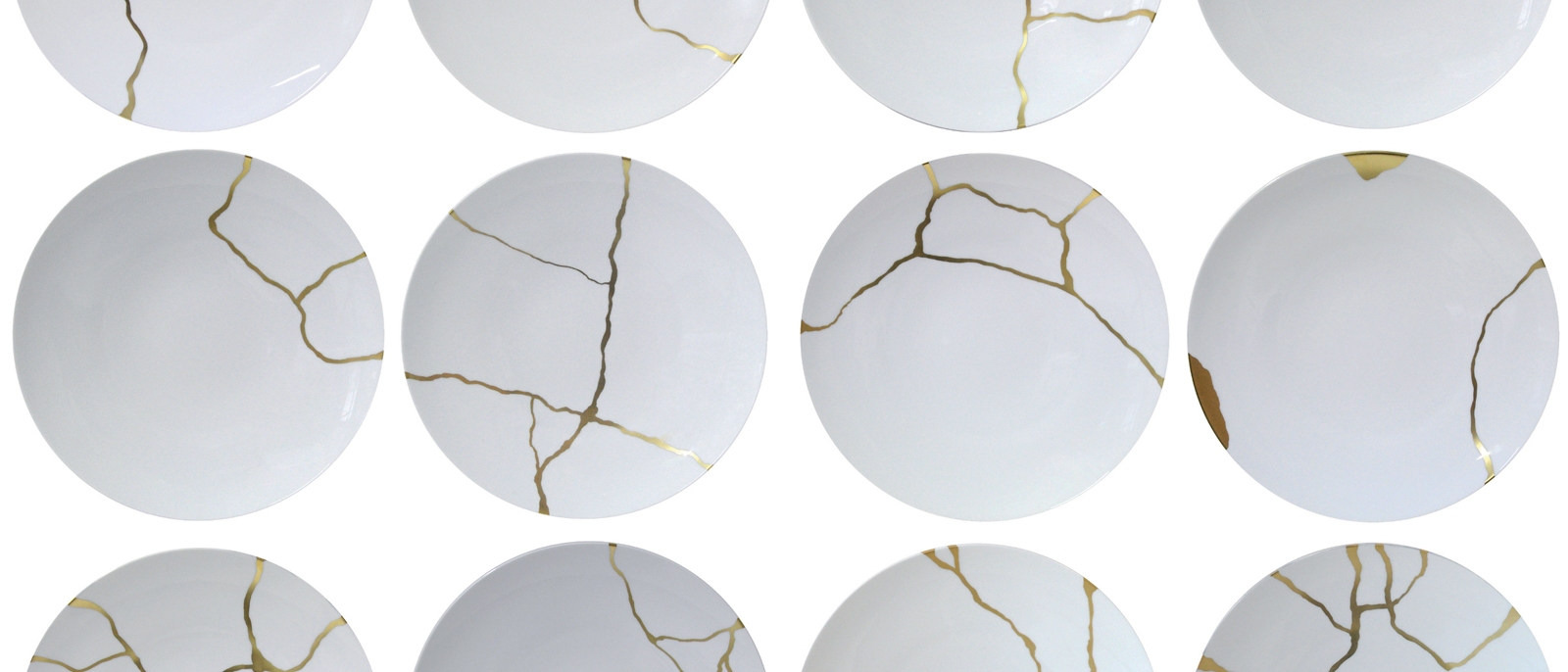 White bowls with the cracks mended with gold to allow the cracks to be shown, rather than hidden.