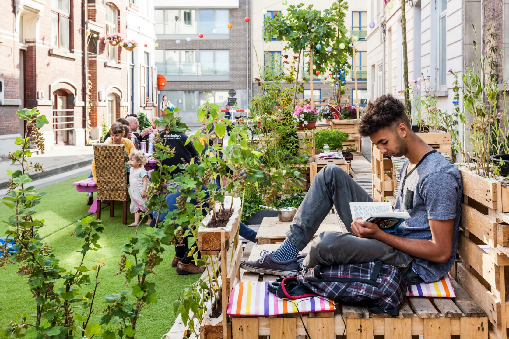 Man sitting on makeshift bench, reading 