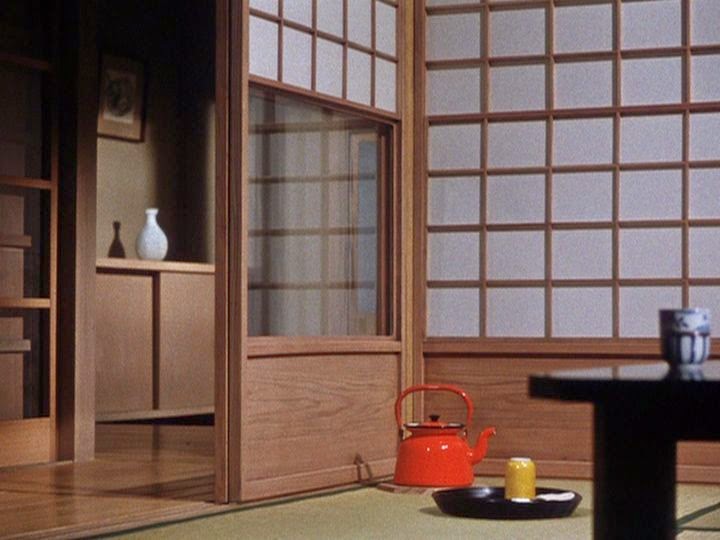 A traditional Japanese home with red tea pot on floor and small table.