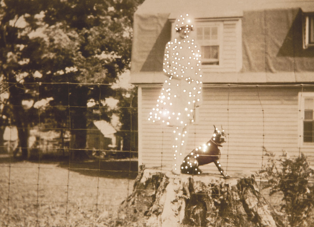 1920s photo of a girl and a dog in a yard.