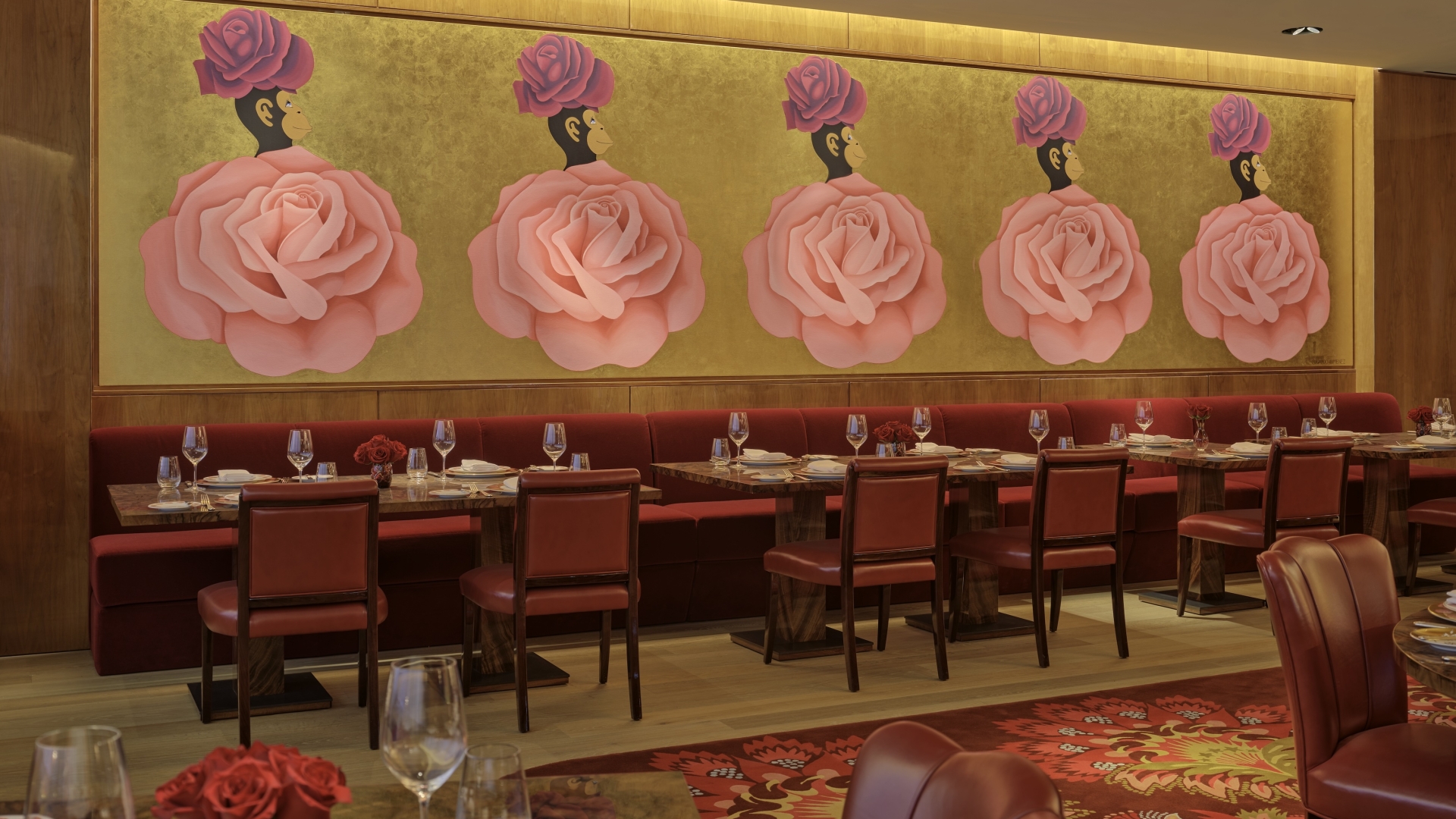 The dining room at La Boca, with gold walls and a mural of white pink roses