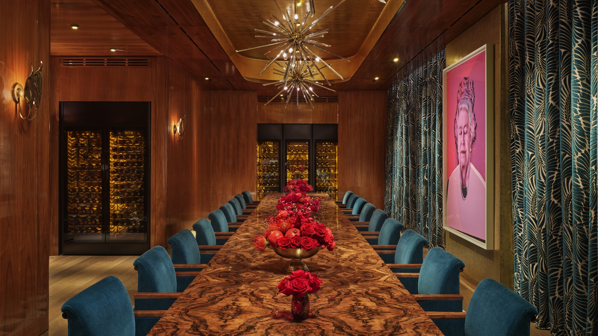 An eclectic private dining room with a long table and a pop art painting of Queen Elizabeth