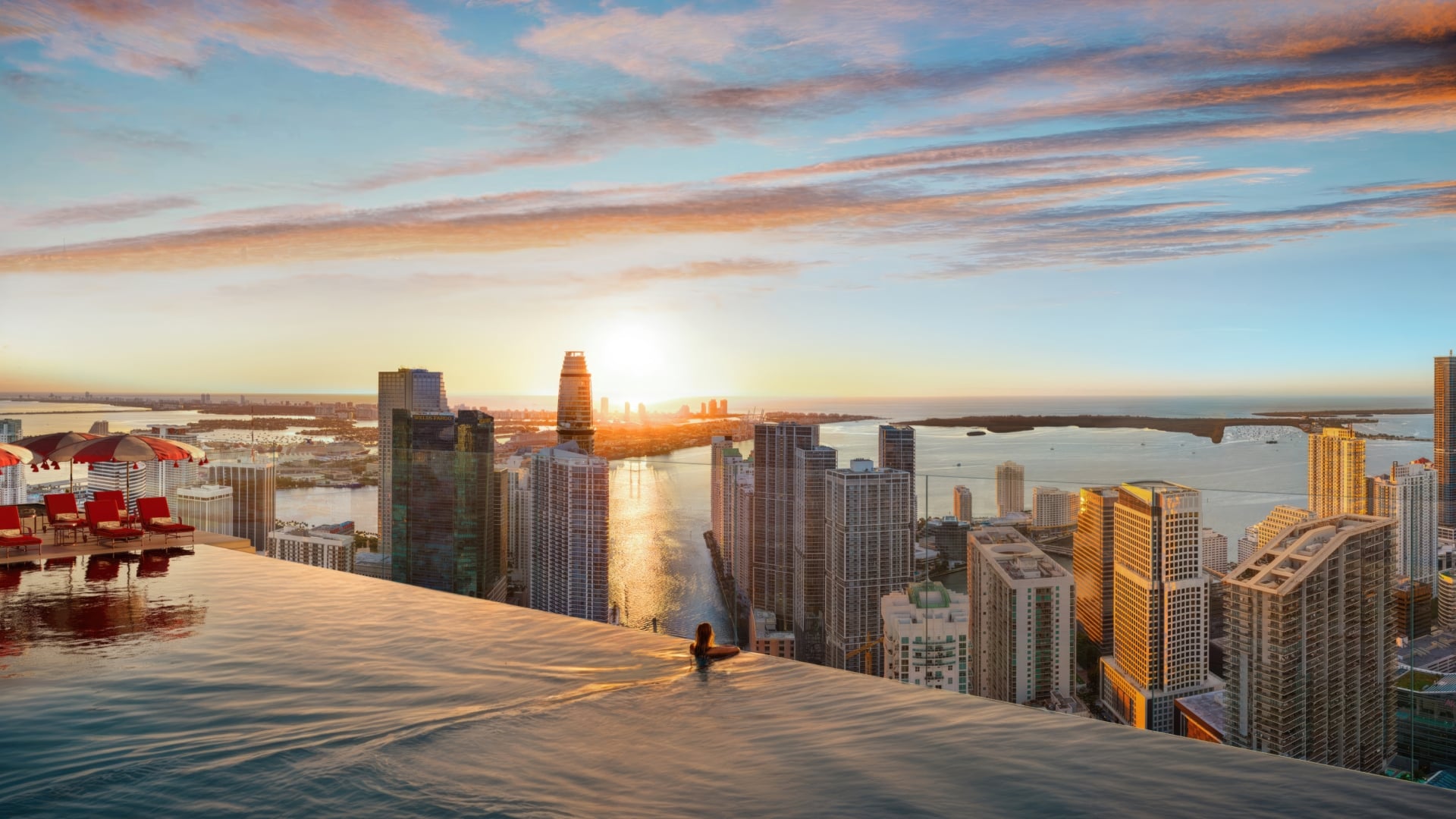 Infinity pool at Faena Residences Miami overlooking the city skyline and waterfront at sunset.