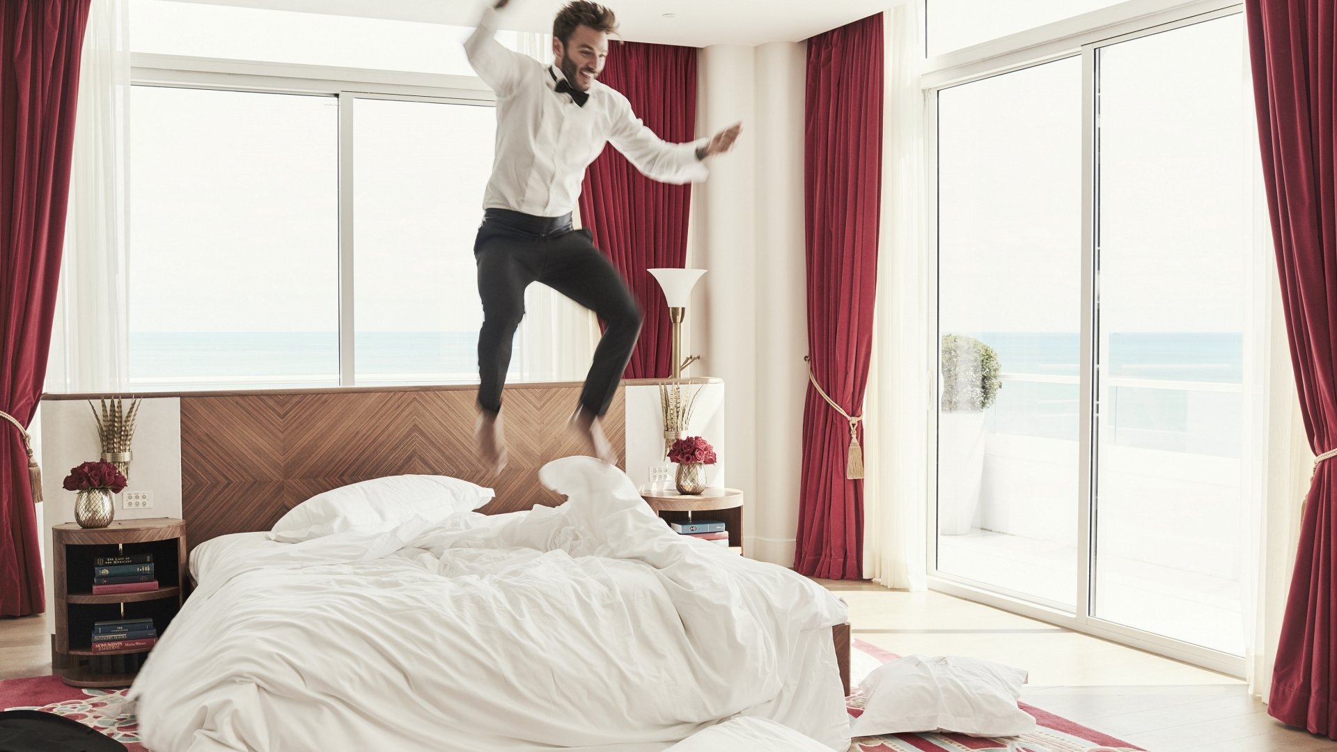 Groom jumping on bed 