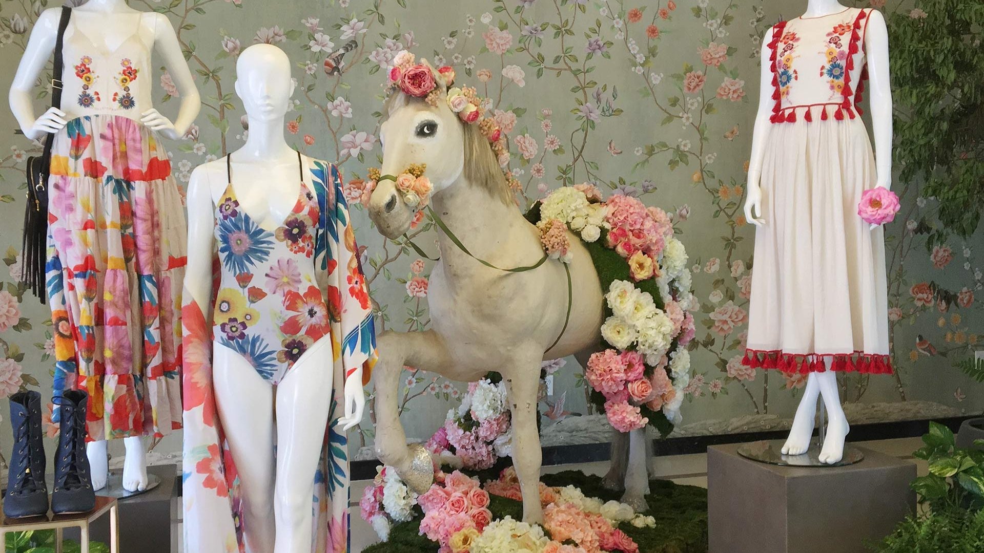 three mannequins in summer clothes and flowers