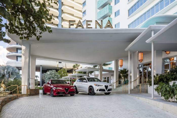 Red and white alfa romeo cars parked in front of Faena hotel