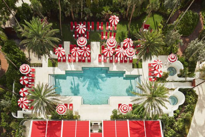 hotel pool with sun umbrellas and palm trees