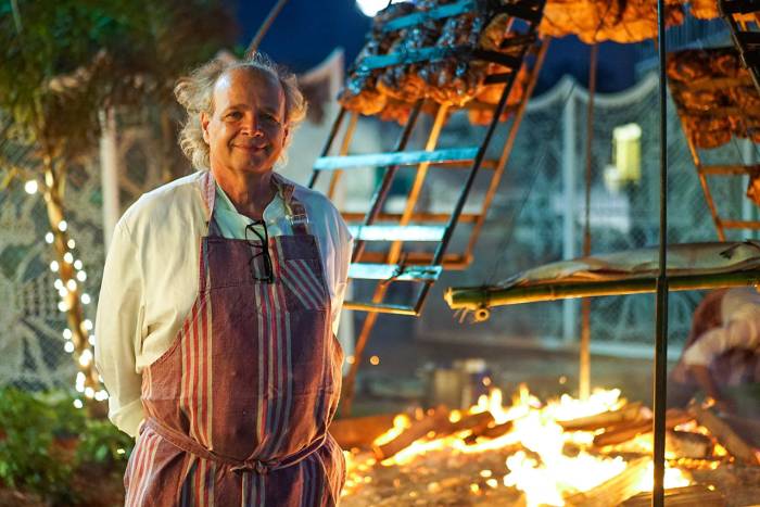 francis mallmann standing in front of open fire cooking
