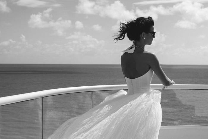 Bride in wedding dress looking out over ocean