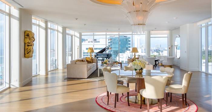 large hotel penthouse with living space and grand piano in the distance