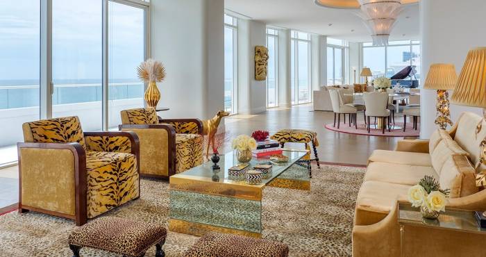 large hotel penthouse with living space and grand piano in the distance