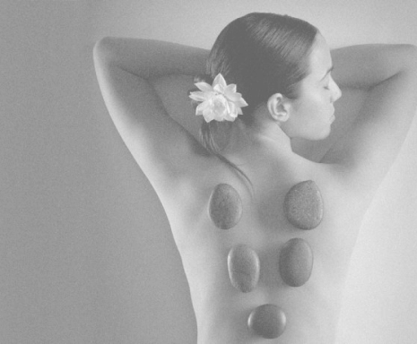 woman lying down with rocks on her back for spa treatment
