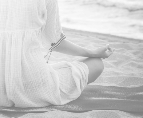 woman on beach sitting in lotus position