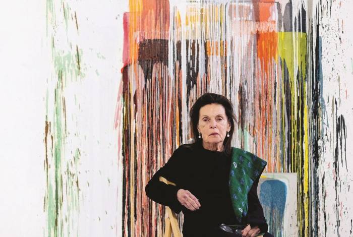 Woman sitting in front of abstract painting