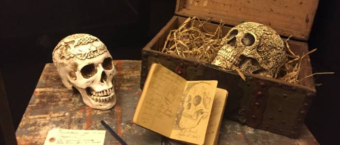 Decorative carved skulls with a sketch book and pen.