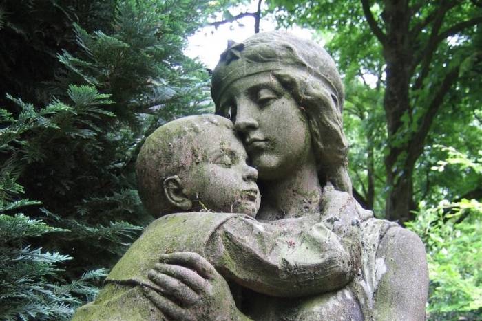 a garden statue of a mother embracing a child