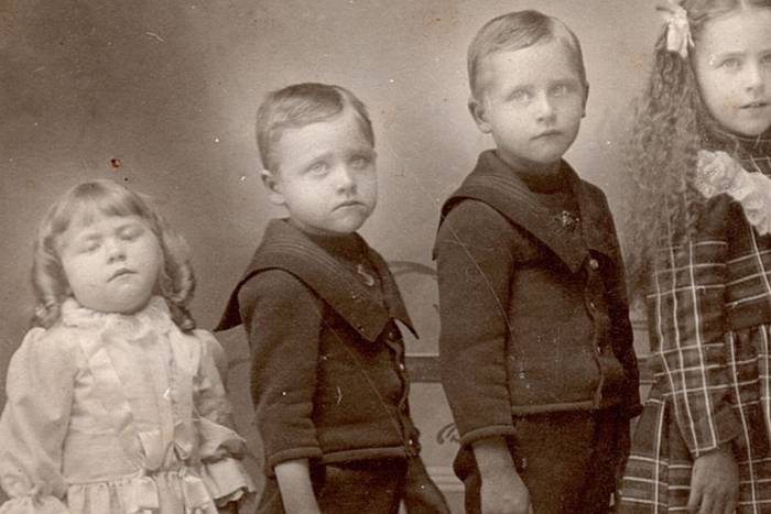 A family photograph of children with a deceased family member