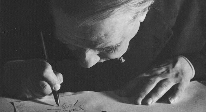 Jorge Luis Borges writing at a desk