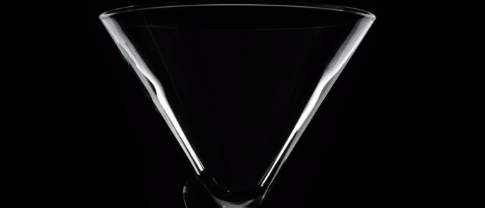 Clear martini glass against black background