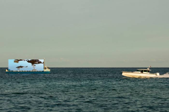 film showing floating screen off shore of Miami Beach