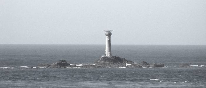 Lighthouse on rocks, on grey day