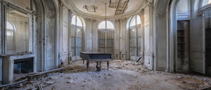 Piano sits in abandoned room.